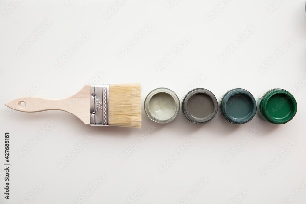 Overhead view of a DIY paint brush with trendy green sample paint pots - obrazy, fototapety, plakaty 