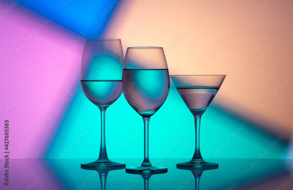 Glass wine glasses on a colored background