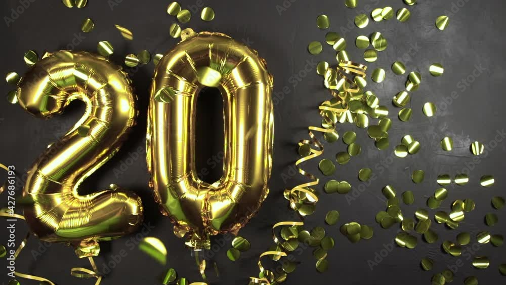 gold foil balloon number twenty. Birthday or anniversary greeting card with inscription 20. Black concrete background. Anniversary celebration. copy space gold foil balloon number twenty. Birthday or anniversary greeting card with inscription 20. Black concrete background. Anniversary celebration. copy space