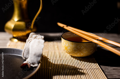 Dark tea background with cup of hot tea on the table. Copy space for your design. Authentic vintage style. Traditional tea ceremony arrangement