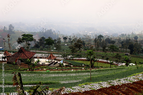 A traditional house building surrounded by village farm on the hill