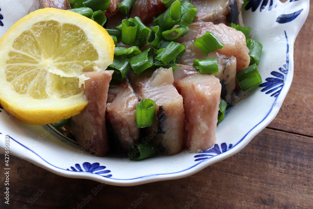 Sliced salted herring fish on a plate with chopped green onion and lemon slice. Swedish pickled herring on wooden table background. Midsummer traditional food. Top view, copy space
Sliced salted herring fish on a plate with chopped green onion and lemon slice. Swedish pickled herring on wooden table background. Midsummer traditional food. Top view, copy space