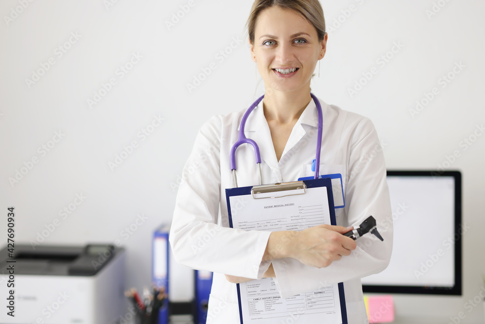 Portrait of woman doctor with medical documents and otoscope in her hands Portrait of woman doctor with medical documents and otoscope in her hands