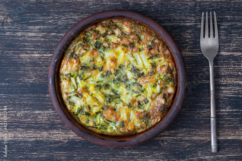 Ceramic bowl with vegetable frittata, simple vegetarian food. Frittata with egg, pepper, green onions and cheese . Healthy egg omelet