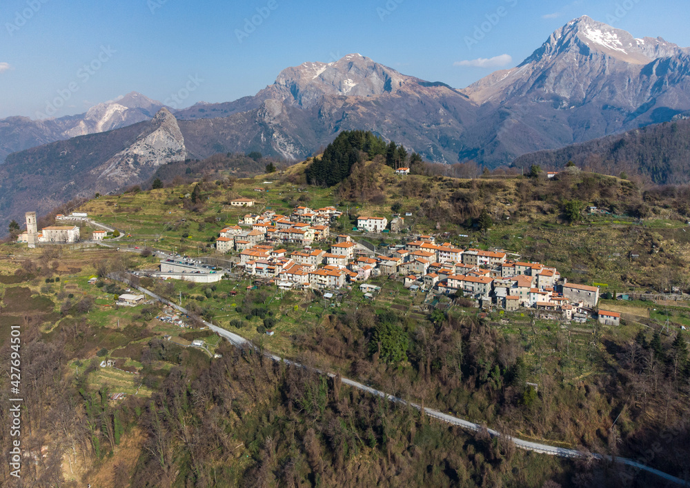 Il paese di Pomezzana in Alta Versilia, sullo sfondo le Alpi Apuane, sulla sinistra il monte Corchia e a destra il monte Pania della Croce.