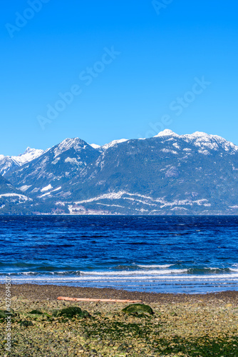 Fantastic view over ocean  snow mountain and rocks at Furry Creek Dive Site in Vancouver  Canada.