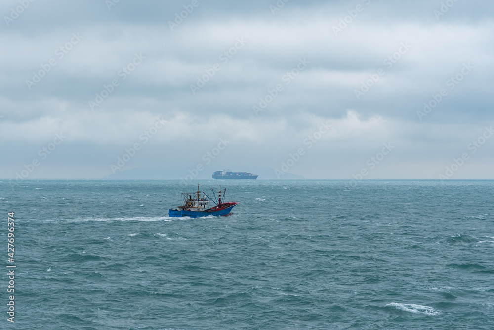 Fishing boat sailing out of the port, for daily routine checking of nets. 