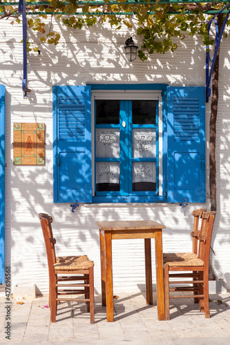 Traditional kafenio (coffee shop) in the Greek island of Paros, in Lefkes village, with its whitewashed walls and traditional wooden chairs and table  photo