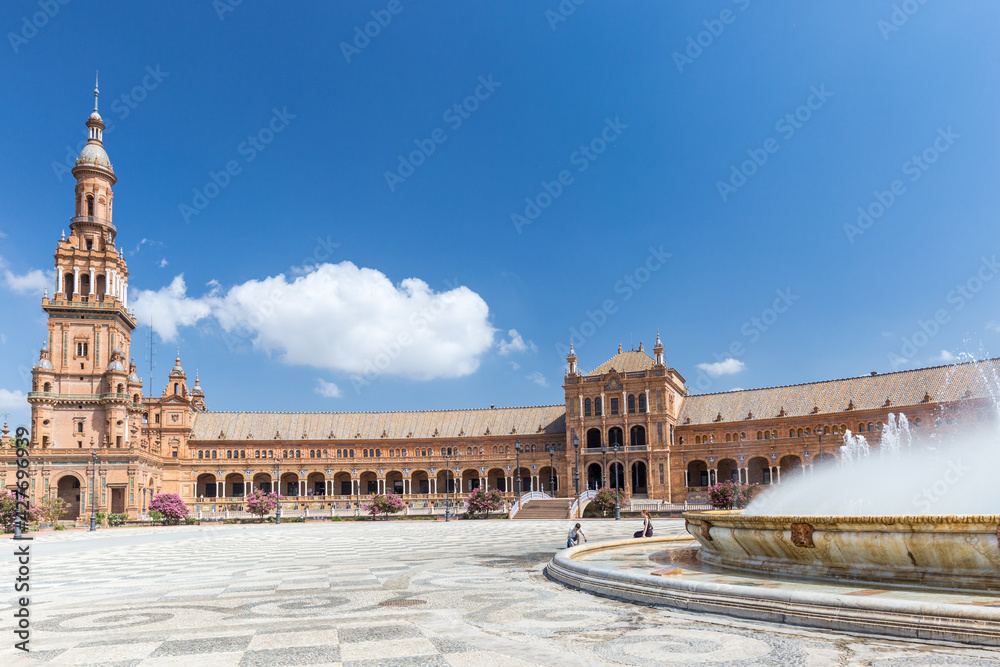 Fountain on Plaza de España. In background beautiful architecture Espana Square. Touristic travel attraction in the center of Seville , empty now due to the Coronavirus measures of isolation. 