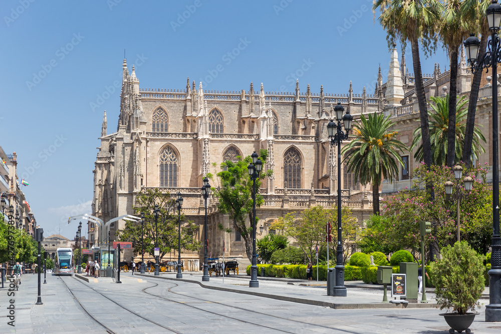 Beautiful city center of Seville with few tourist due the Coronavirus isolation measures. In background the Cathedral of Seville. Tram rails, trams at the station.