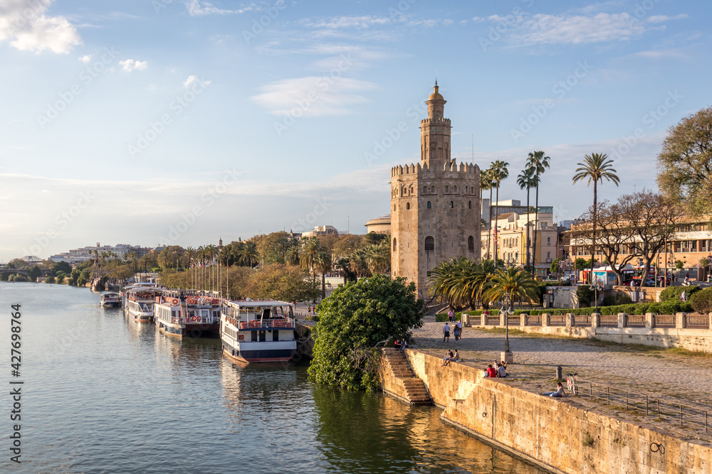 View of the Guadalquivir river and the Torre del Oro in Seville Spain. Typical postcard of the city.