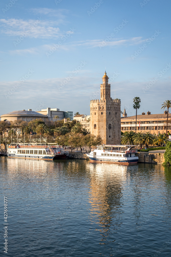 View of the Guadalquivir river and the Torre del Oro in Seville Spain. Typical postcard of the city. Vertical view.