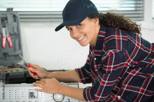 young woman fixing a machine