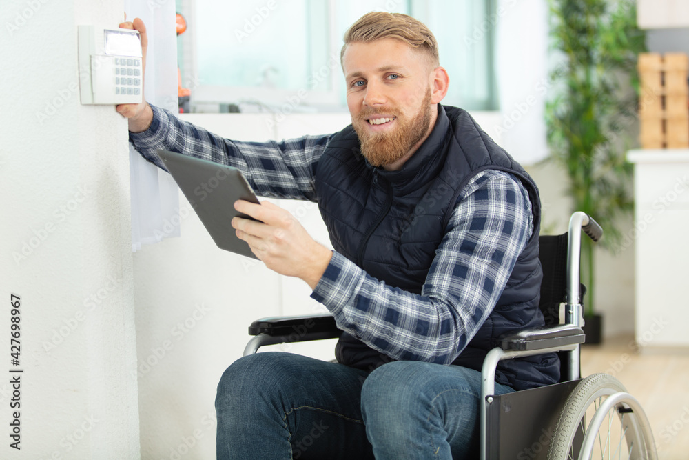 disabled worker in wheelchair installing alarm disabled worker in wheelchair installing alarm