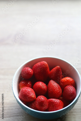 Bowl of fresh strawberries on a table. Selective focus.