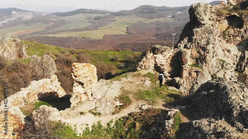 Young female hiker outdoors explores historical Kojori fortress ruins in Georgia. Travel destination caucasus. photo