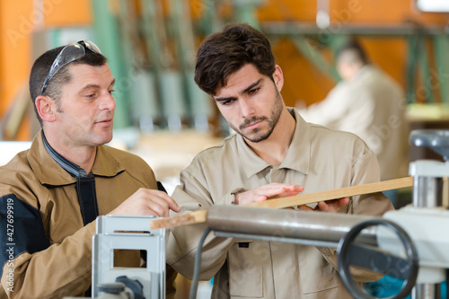 two workers in a carpenters workshop