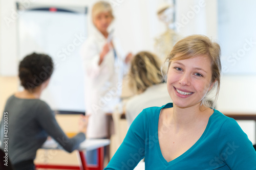student smiling and class at the background