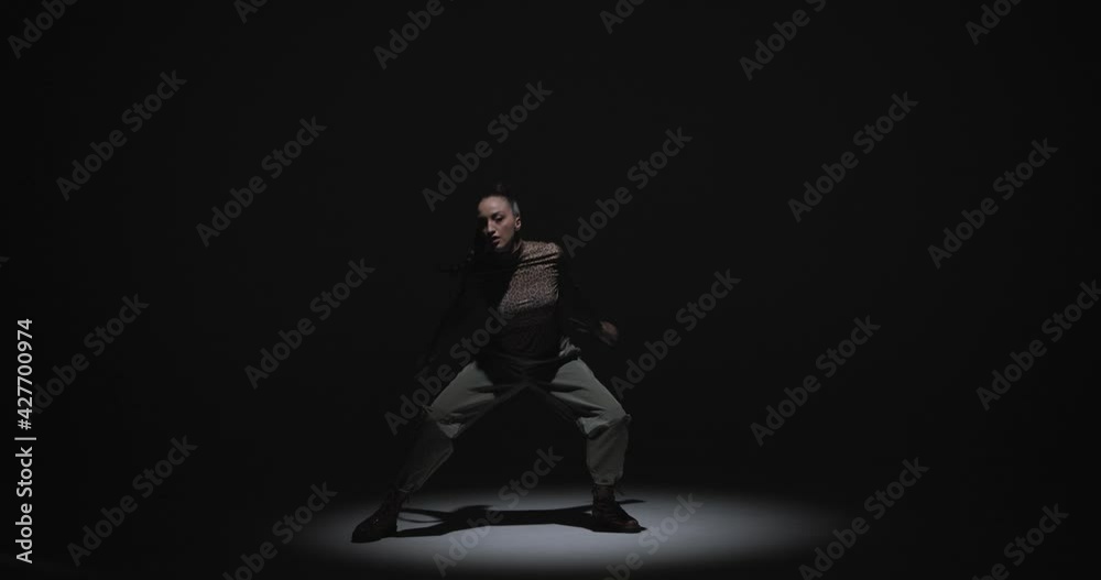 African ethnic expressive passionate female dance. Cool stylish girl dancing in black studio at spotlight African ethnic expressive passionate female dance. Cool stylish girl dancing in black studio at spotlight