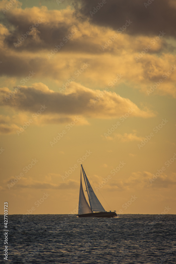 sailboat at sunset in calm waters