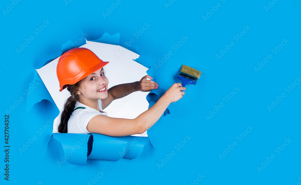 Trust me I am an expert. kid wear helmet on construction site. teen girl  painter with painting brush tool. child on repairing work. concept of  renovation in workshop. busy professional carpenter Stock