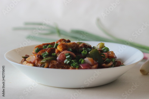 Air fried cottage cheese cubes and baby corn prepared with chilli sauce. It is an Indo Chinese dish, locally known as chilly paneer with baby corn photo