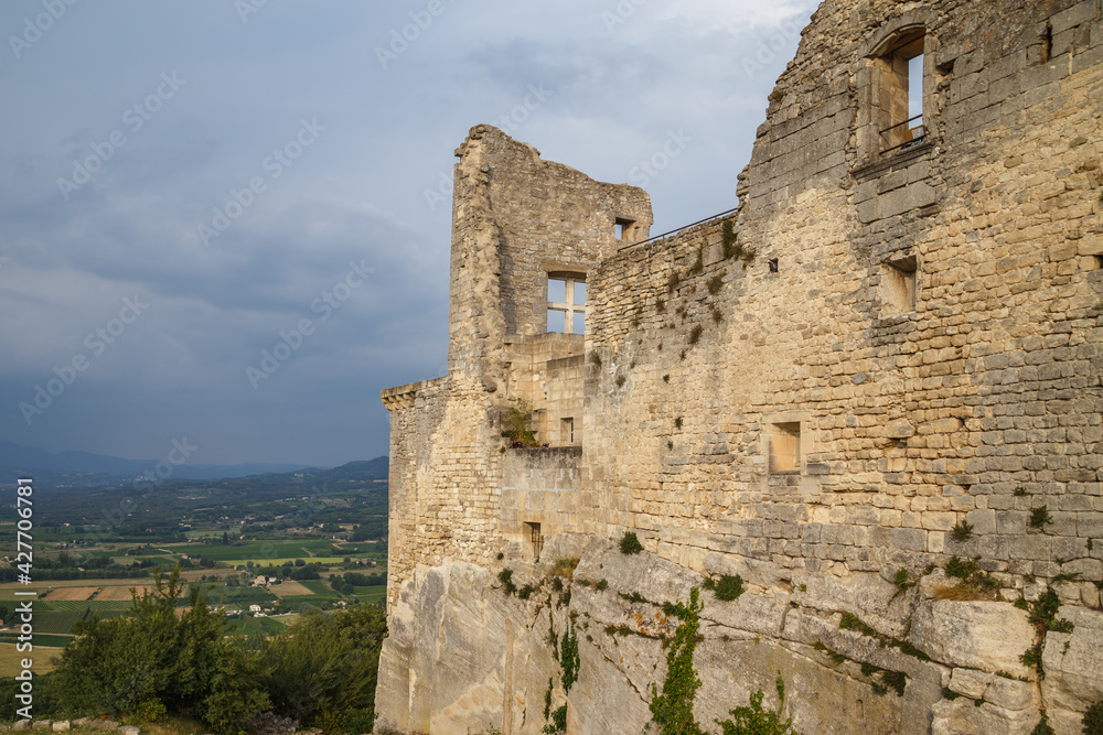 Lacoste, Provence, France. Ruined stone walls with windows of the Castle of Marquis de Sade. Provence countryside in the background.