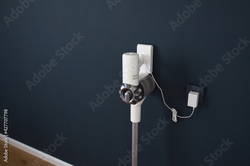 Foto Charging modern cordless vacuum cleaner. Close-up.