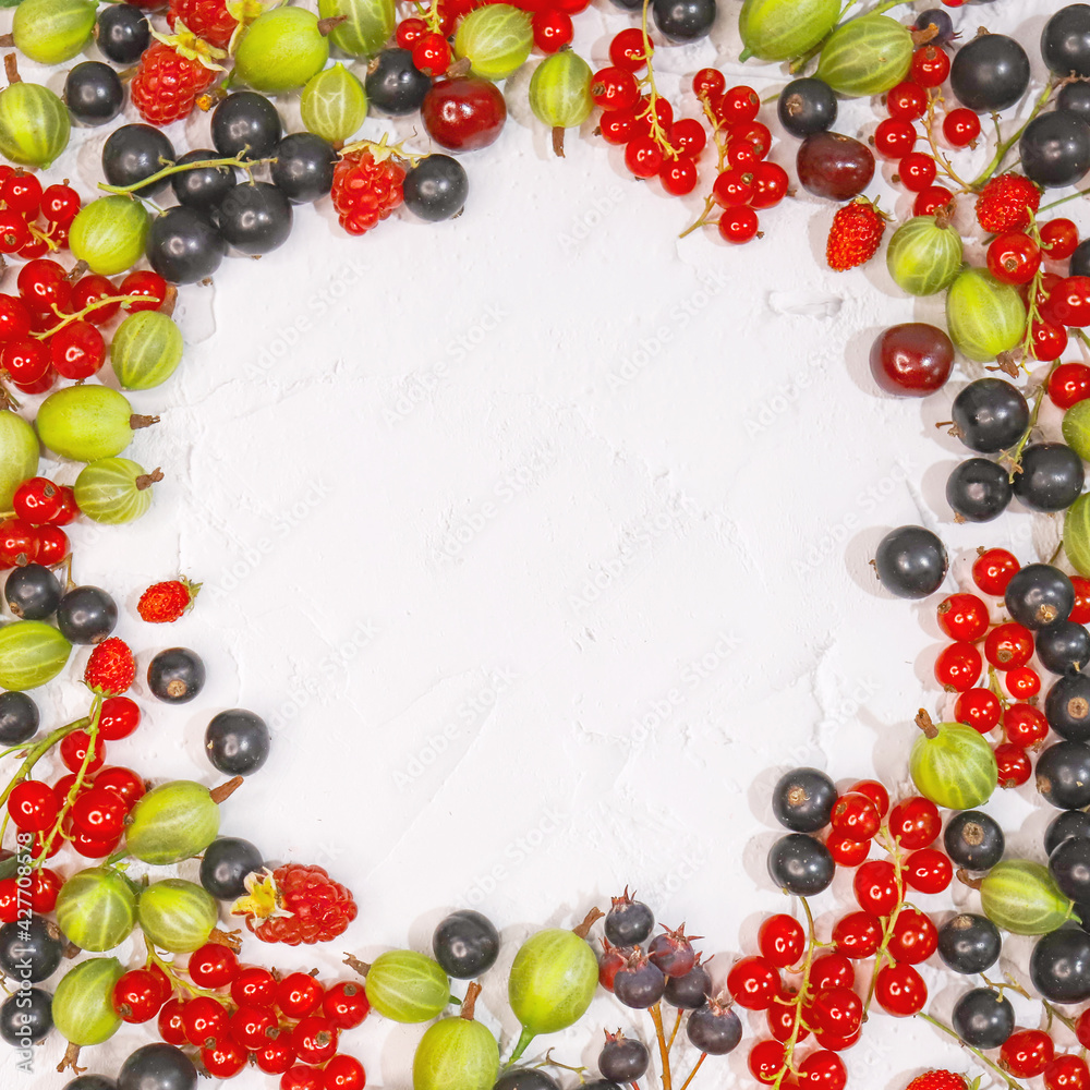 Fresh ripe berries, cherries, raspberries, currants and gooseberries on white background in form of frame. Place label in center. Summer berries, harvest concept, vitamin food, veganism.