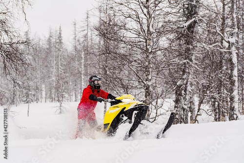 Mountain snowmobile riders ride on the slopes