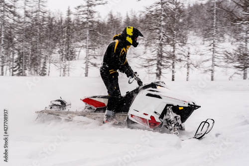 Mountain snowmobile riders ride on the slopes