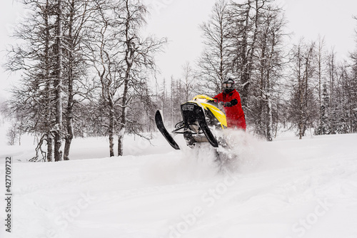 Mountain snowmobile riders ride on the slopes