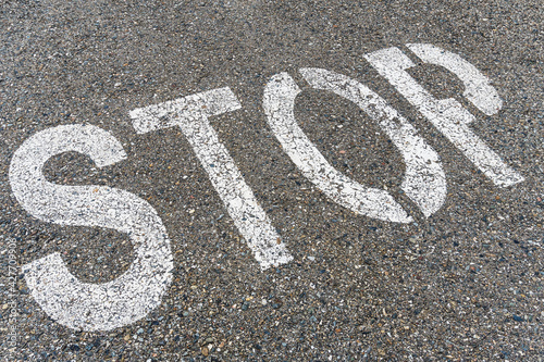 STOP sign on the road with textured asphalt.