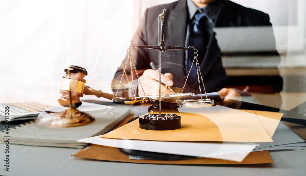 Business and lawyers discussing contract papers with brass scale on desk in office. Law, legal services, advice, justice and law concept picture with film grain effect