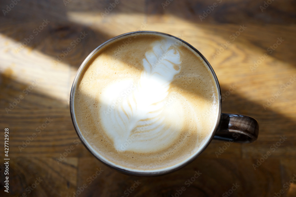 Cup of cappuccino on a wooden table in a better light Cup of cappuccino on a wooden table in a better light