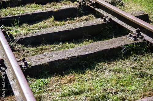 Stare drewniane szyny podkłady kolejowe zarośnięte trawą