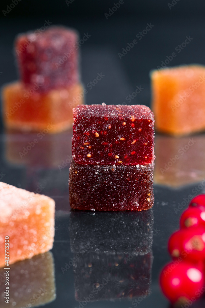 A colorful French fruit jellies (Pâte de fruits) isolated black