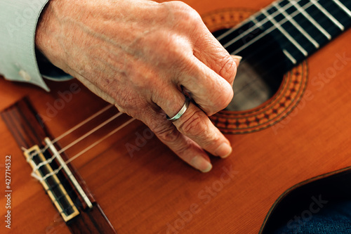 Close Up On The Hands Of An Old Guitarist Playing Acoustic Guitar