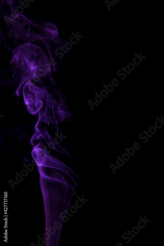 Abstract purple smoke swirling on a black background.