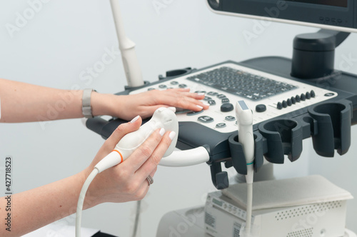 A female doctor holds an ultrasound sensor in close-up. Medical equipment. photo
