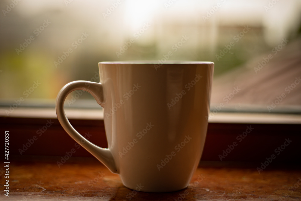 Steaming coffee cup on a rainy day window background Steaming coffee cup on a rainy day window background
