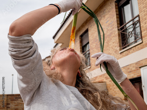 Spanish woman eating tender onion grill with tomato sauce, typical Spanish product photo