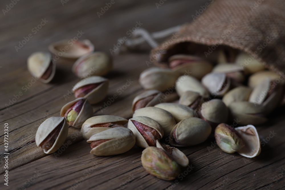 delicious pistachios in a shell on a textured wooden table delicious pistachios in a shell on a textured wooden table