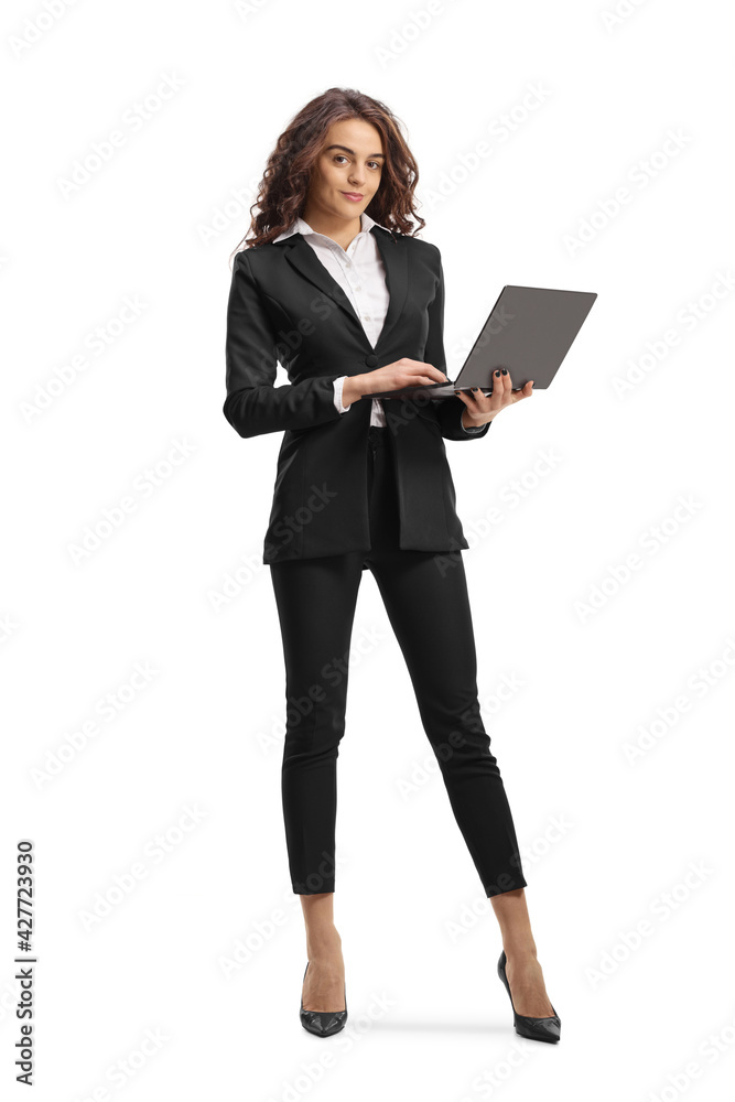 Full length portrait of a young businesswoman standing and working on a laptop computer Full length portrait of a young businesswoman standing and working on a laptop computer