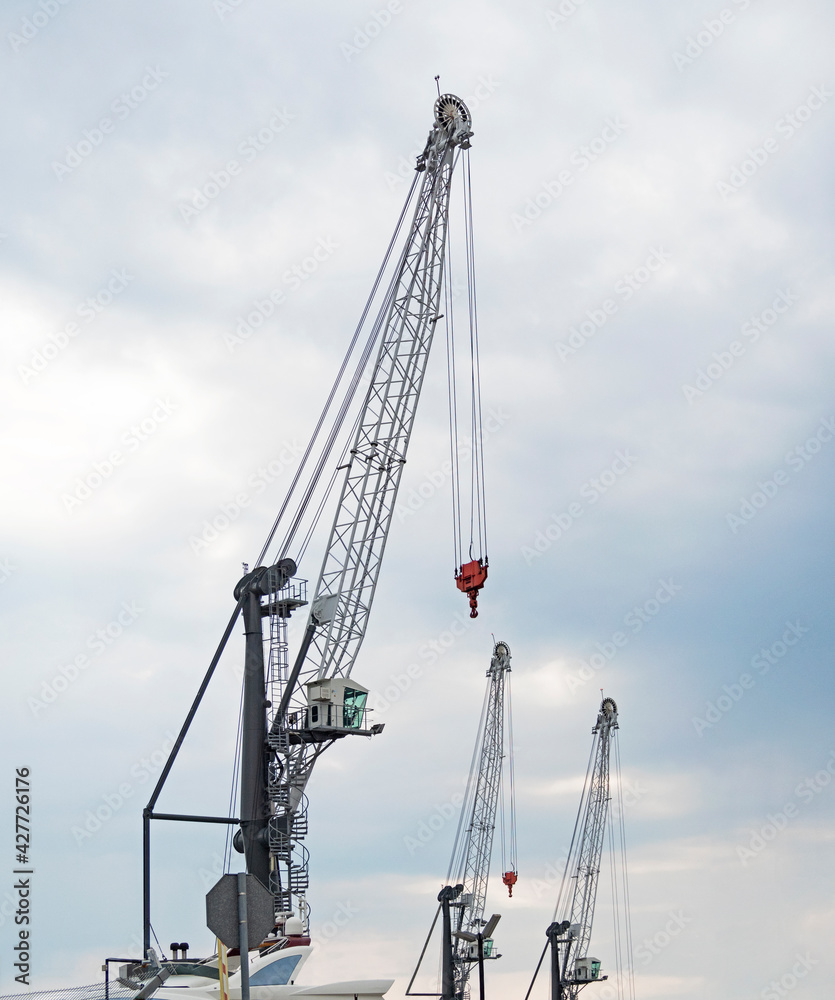 Fototapeta premium Group of construction lifting cranes at sky background