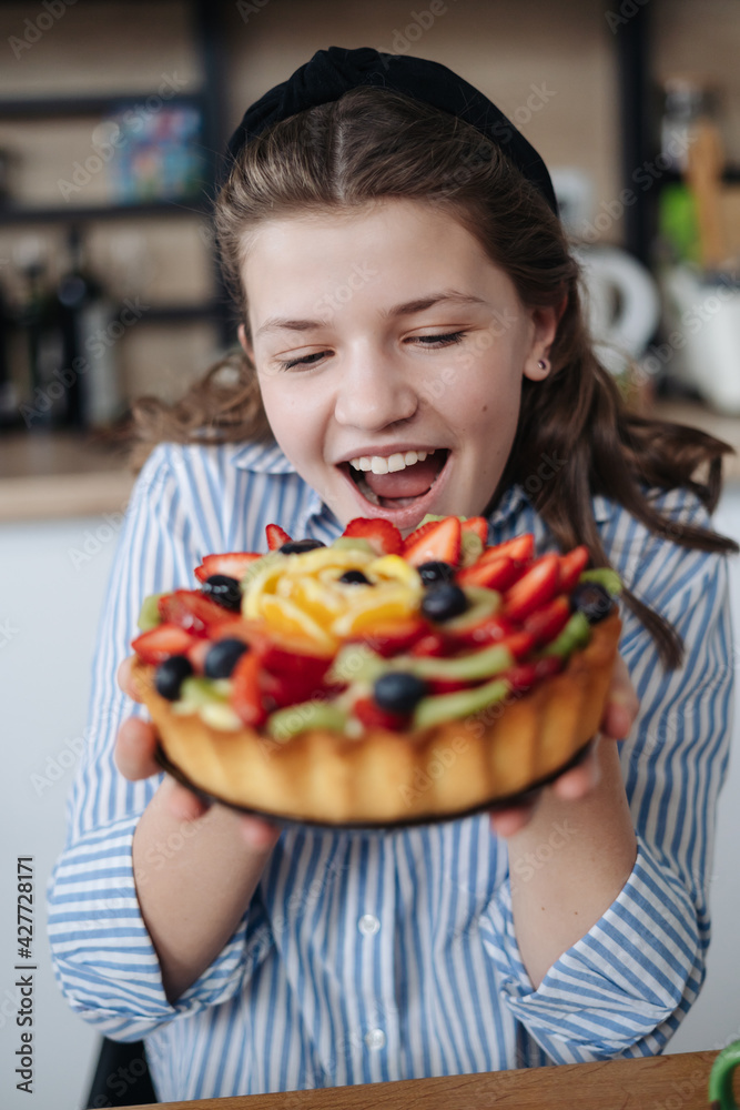 Adorable girl holding a Very berry cake. Tart with berries. Emotions concept