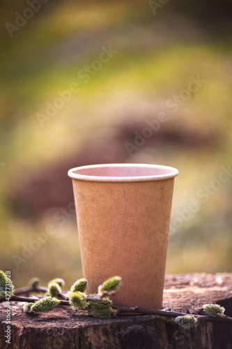 A paper craft brown cup from a coffee shop for coffee, tea or cocktails take with you and to go. For mockup, nature background. 