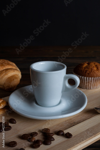 A mug of aromatic morning coffee with cinnamon, anise stars, and cookies on a wooden background. Retro. 