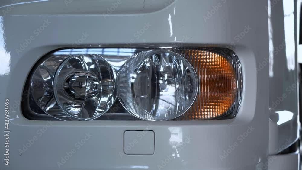 Close up Headlights of White lorry parked in a truck service station.