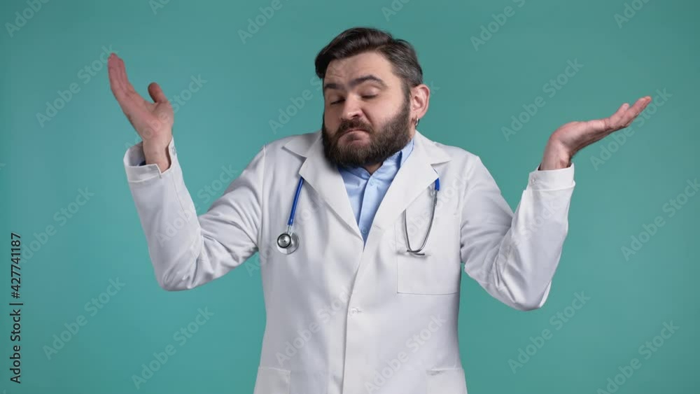 Indifferent unsure doctor man makes gesture of I dont know, cant help anything. Difficult question concept. Blue studio background. Indifferent unsure doctor man makes gesture of I dont know, cant help anything. Difficult question concept. Blue studio background.